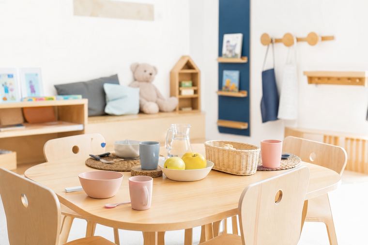 Tavolo del nido apparecchiato per il pranzo dei bambini con piatti e bicchieri allineati